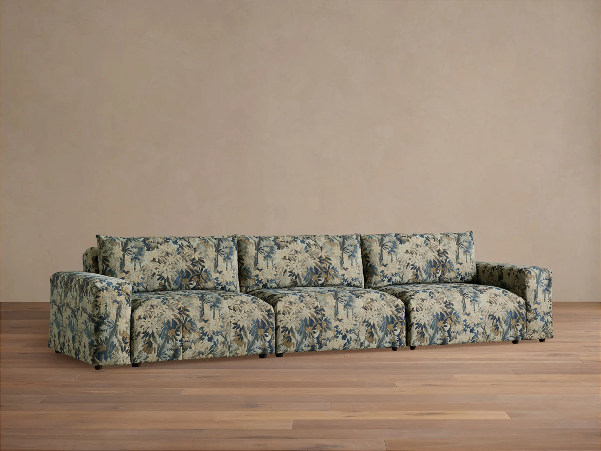 Keegan Three Piece Modular Sofa, upholstered in blue, beige, and brown floral fabric, front view, on a wooden floor.