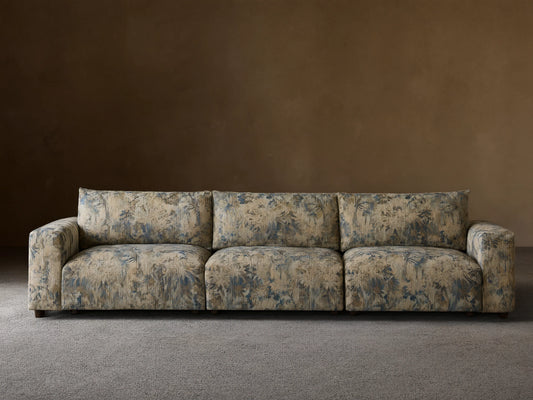 Keegan Three Piece Modular Sofa, upholstered in blue, beige, and brown floral fabric, front view, on a wooden floor.