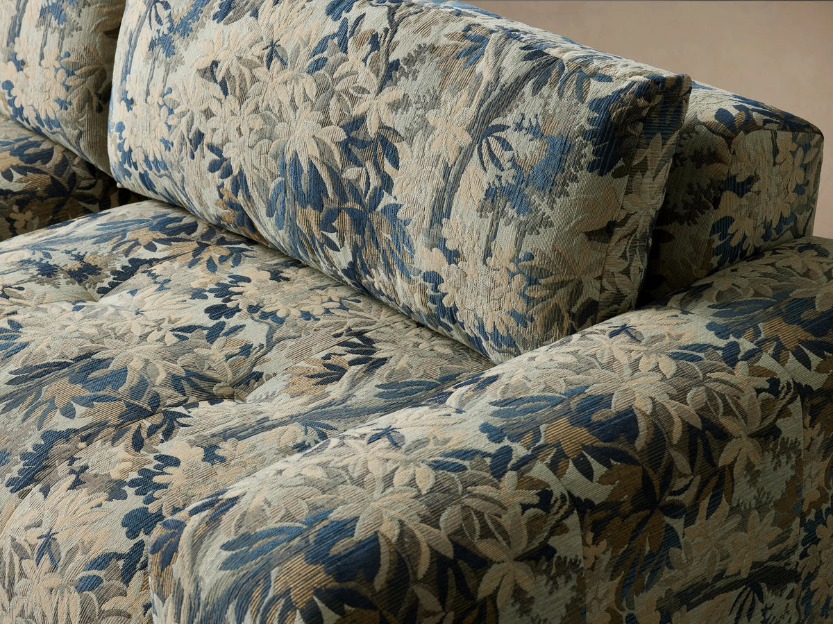 Keegan Three Piece Modular Sofa with blue, green, and beige tropical foliage pattern, against a light wall.
