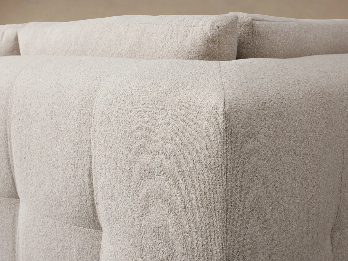 Keegan Four Piece Sectional sofa, light beige textured fabric, L-shaped with chaise, on wood floor.