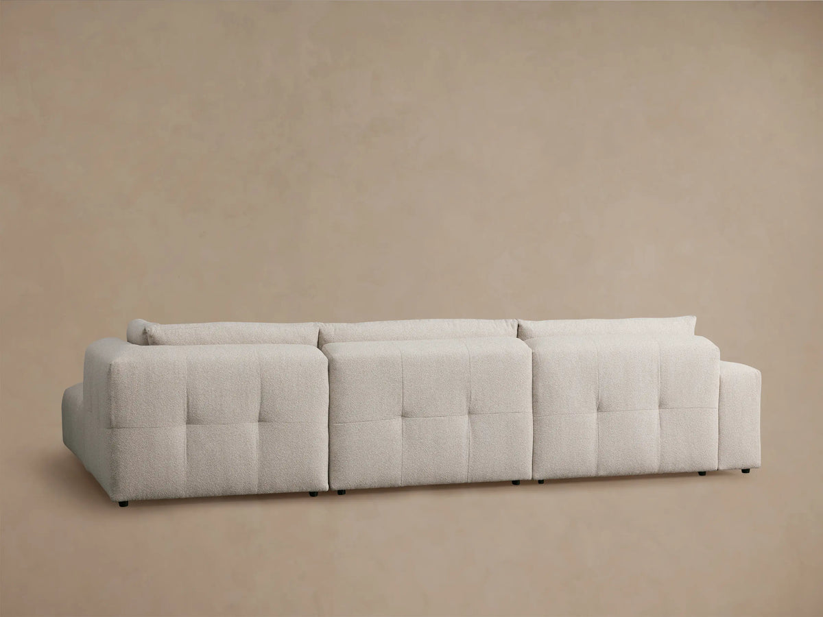 Keegan Sectional close-up: textured light beige fabric on the back cushions, showing subtle vertical seaming details.