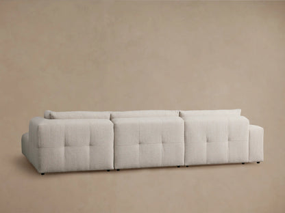 Keegan Sectional close-up: textured light beige fabric on the back cushions, showing subtle vertical seaming details.