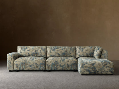 Keegan Four Piece Sectional with Ottoman, L-shaped, upholstered in light beige, blue, and brown tropical leaf pattern.