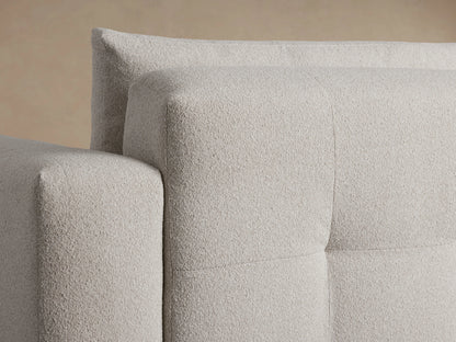Keegan Five-Piece Corner Sectional in beige fabric, L-shaped design on wooden floor, against a beige wall. Plush cushions, low-profile.