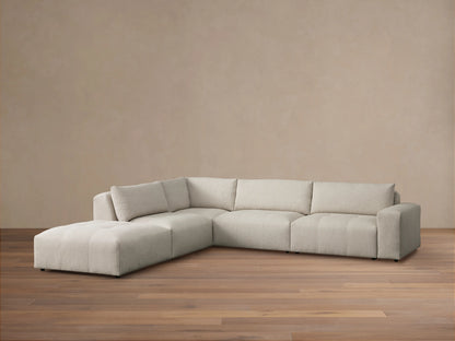 Front view of the Keegan Five-Piece Sectional in blue and beige floral pattern, with throw pillows, in a sunny living room.