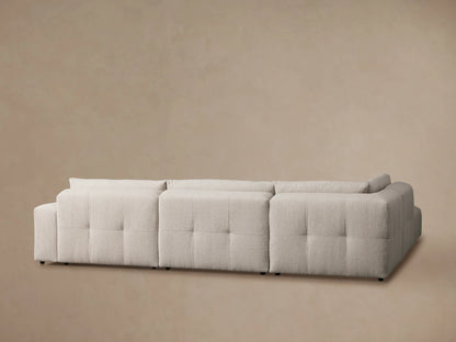 Close-up of the Keegan Five-Piece Sectional's textured beige fabric and cushioned backrest, showing detailed stitching.