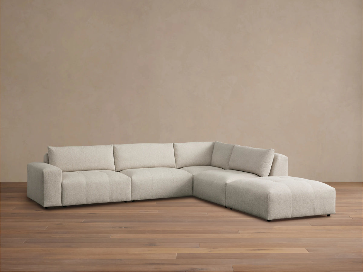 Front view of the Keegan Five-Piece Sectional, upholstered in blue and beige botanical print, in a sunlit living room.