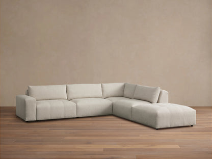 Front view of the Keegan Five-Piece Sectional, upholstered in blue and beige botanical print, in a sunlit living room.