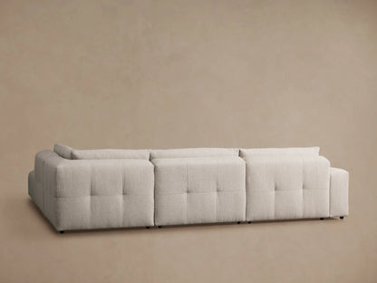Keegan Five-Piece Sectional with textured beige fabric, showing a close-up of its tufted backrest and cushion seams.