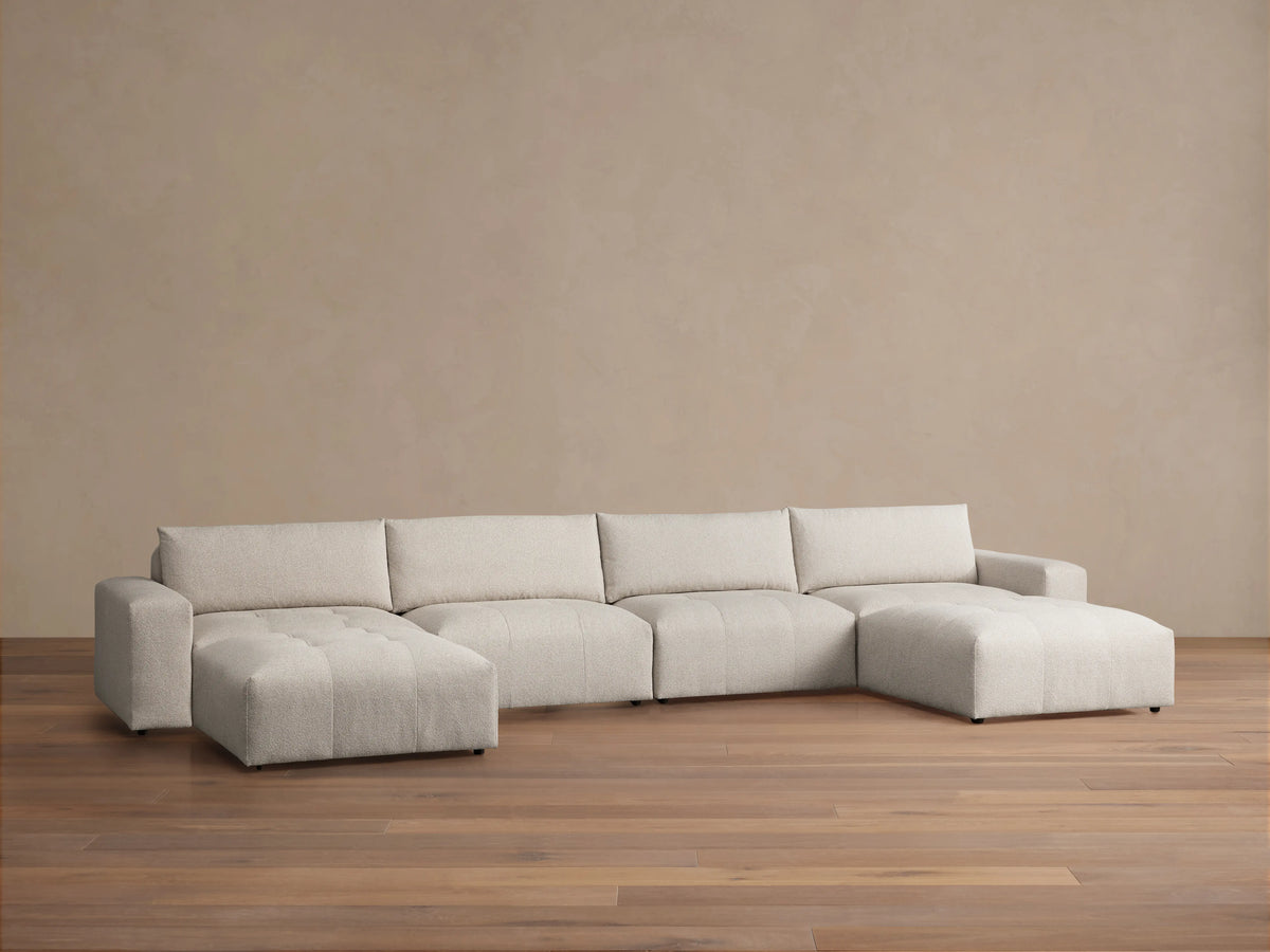 Keegan Six-Piece Sectional in light beige fabric on wooden floor, featuring clean lines and low-profile design with plush cushions.