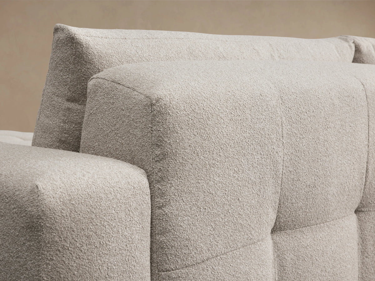 Keegan Six-Piece Sectional in light beige fabric on a wooden floor, featuring broad cushions and a spacious chaise on both ends.
