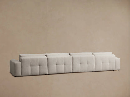 Back view of the Keegan Six-Piece Sectional in light gray fabric, showcasing its rounded and plush cushions with visible stitching.