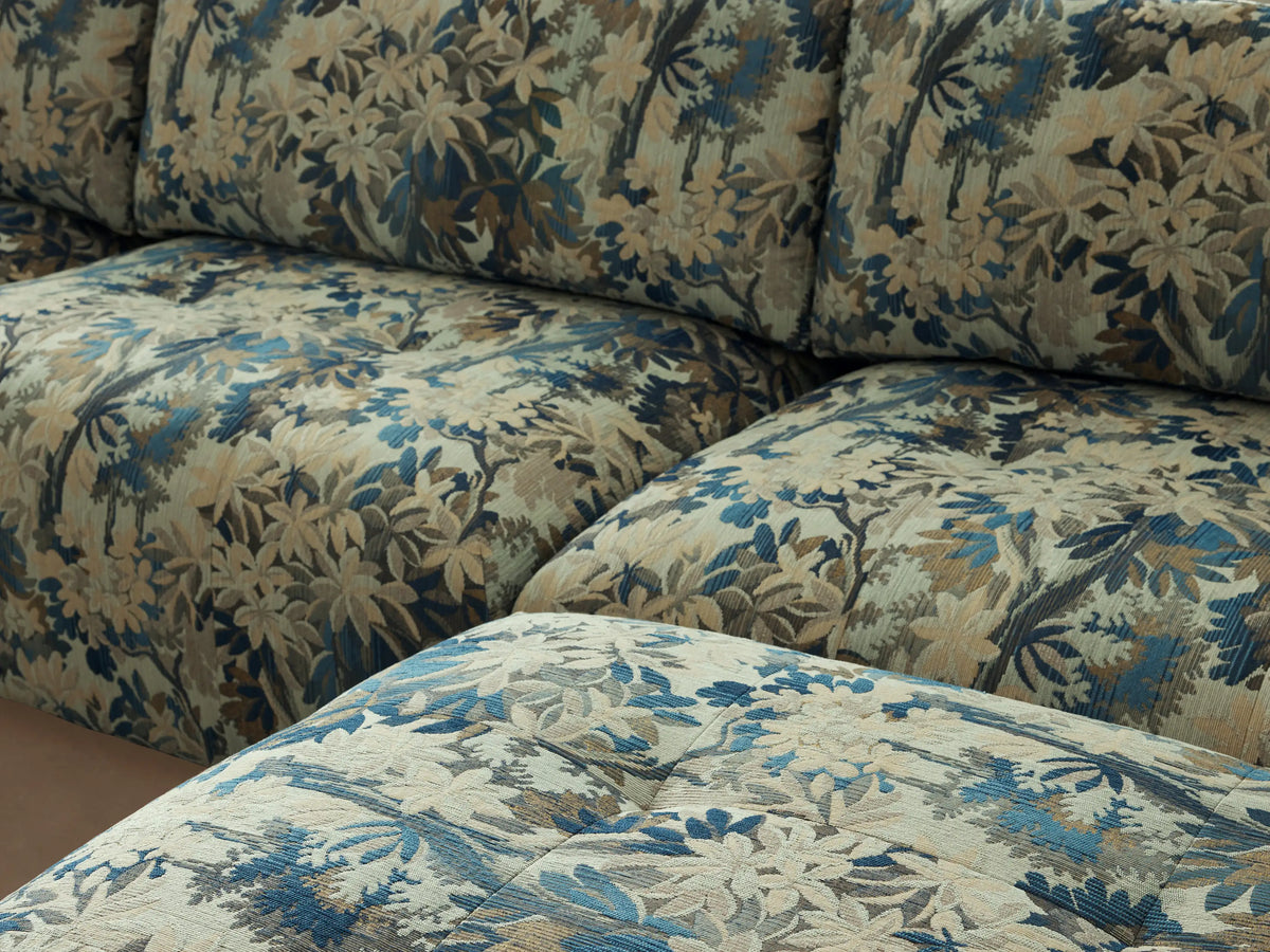 Keegan Six-Piece Sectional sofa, U-shaped, upholstered in light beige fabric with blue and green botanical print, on a wooden floor.