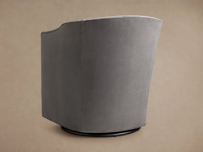 Giles Swivel Chair in grey fabric featuring a smooth, curved backrest and armrest. The upholstery has a soft, velvety texture.