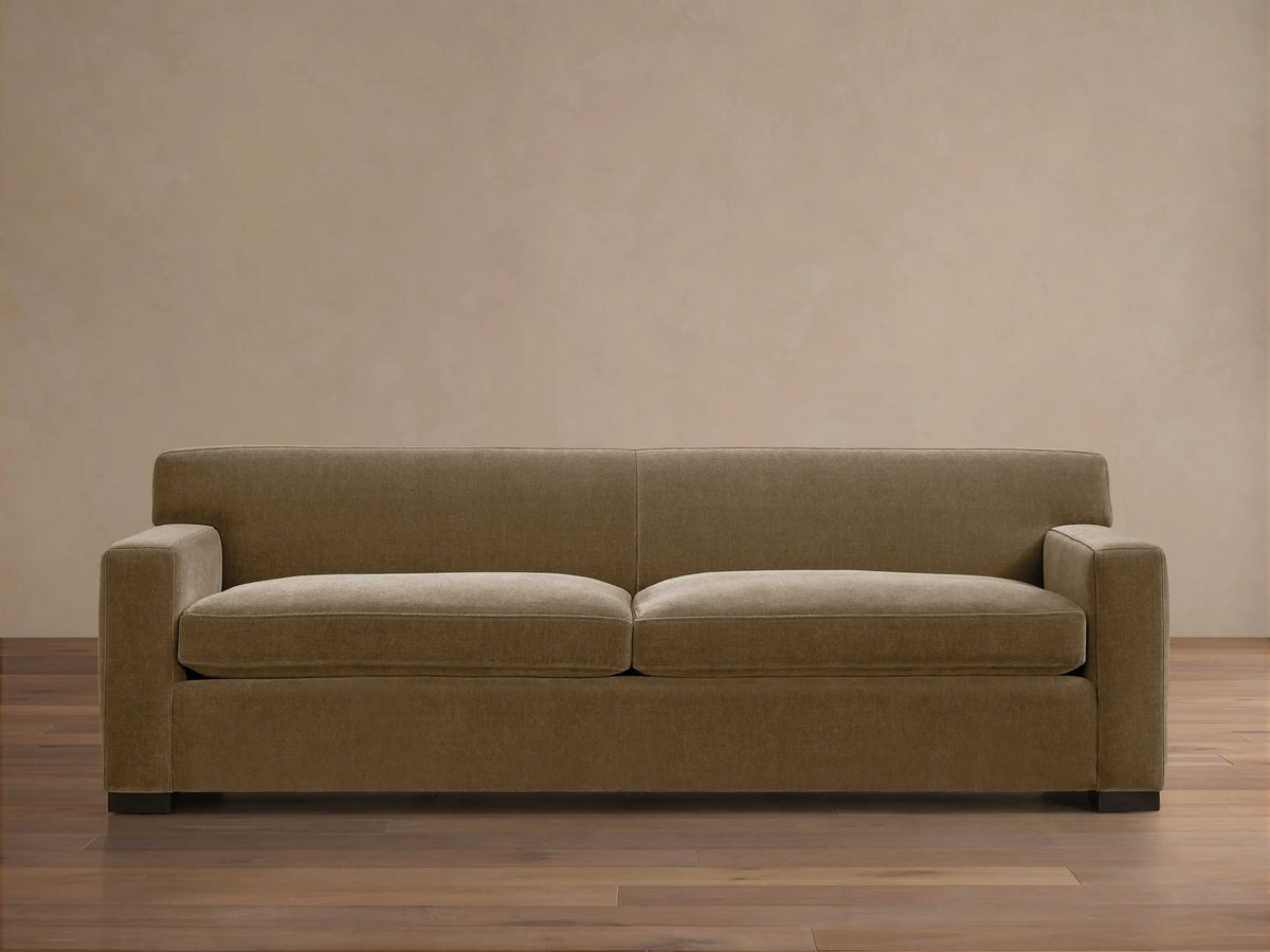 Bronte Sofa: Modern, muted olive green fabric sofa with straight lines, square arms, and dark feet on a wood floor.