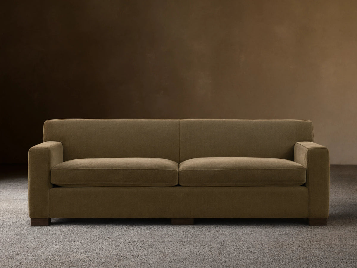 Bronte Sofa: Modern, muted olive green fabric sofa with straight lines, square arms, and dark feet on a wood floor.