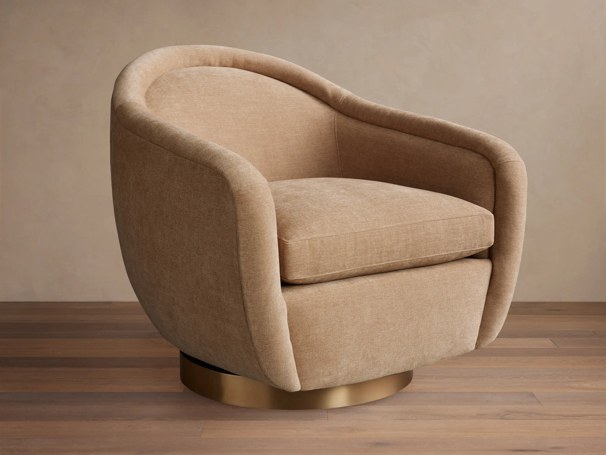 Ashbury Swivel Chair in light beige fabric, featuring a rounded back, wide arms, and a gleaming brass swivel base.
