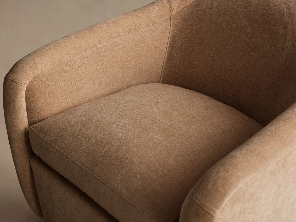 Ashbury Swivel Chair, light beige upholstered, rounded modern design, with a single seat cushion and a gold swivel base.