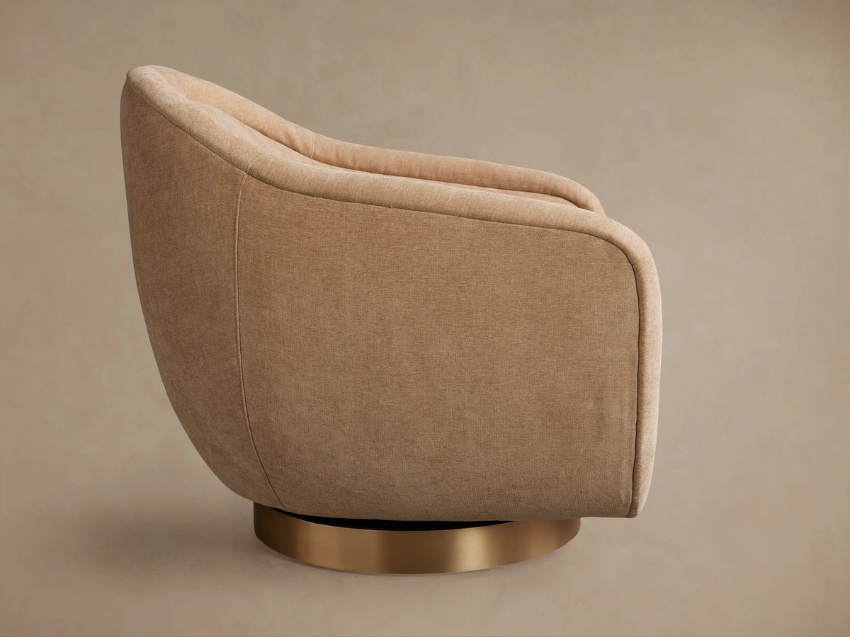 Ashbury Swivel Chair, back 3/4 view. Rounded beige upholstered chair with textured fabric and a gold metallic swivel base.