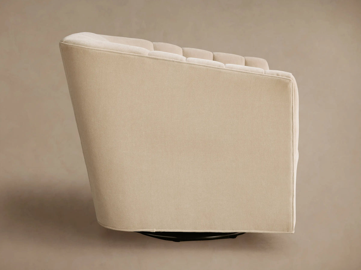 Angled Ellison Channel-Stitched Swivel Chair in cream fabric, showing its back and side. Features subtle channel stitching & black swivel base.