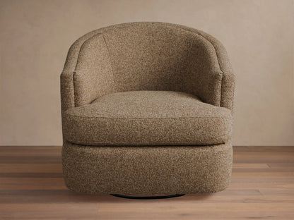 Kieran Swivel Chair with a curved backrest and cushioned seat in a textured beige fabric, placed on a wooden floor.