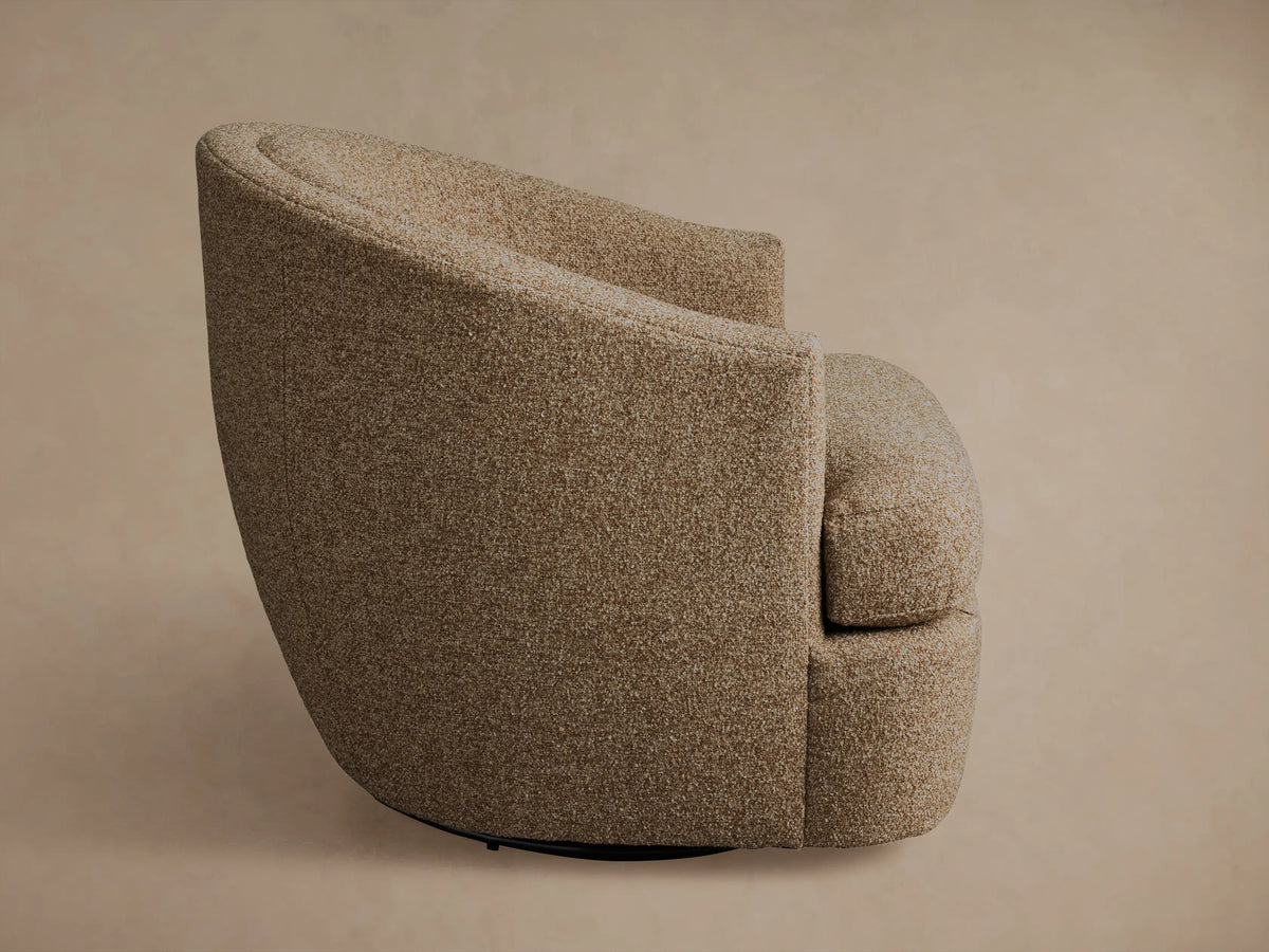 Kieran Swivel Chair in close-up view, showcasing textured, brown fabric upholstery with a curved backrest and seamless arm design.