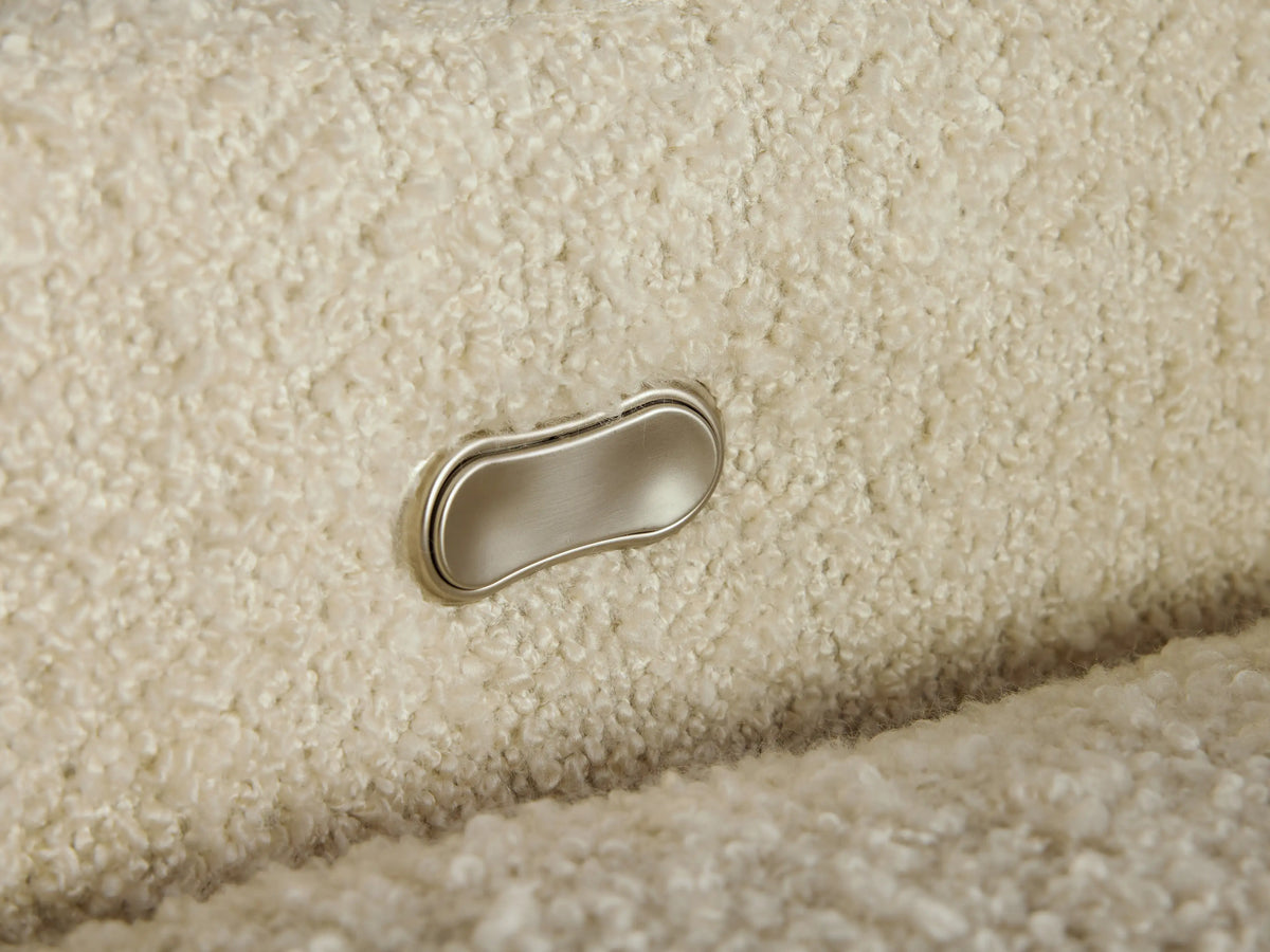 Close-up of Colfax Motion Recliner's textured, creamy white boucle fabric upholstery, showing backrest cushion.