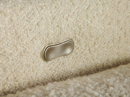 Close-up of Colfax Motion Recliner's textured, creamy white boucle fabric upholstery, showing backrest cushion.