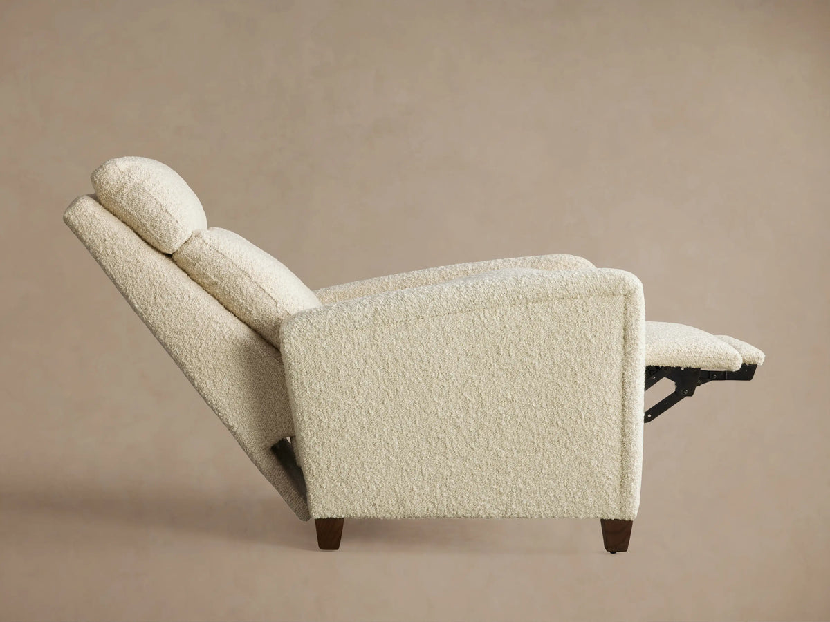 Close-up of the Colfax Motion Recliner's silver two-button motion control embedded in textured cream fabric.