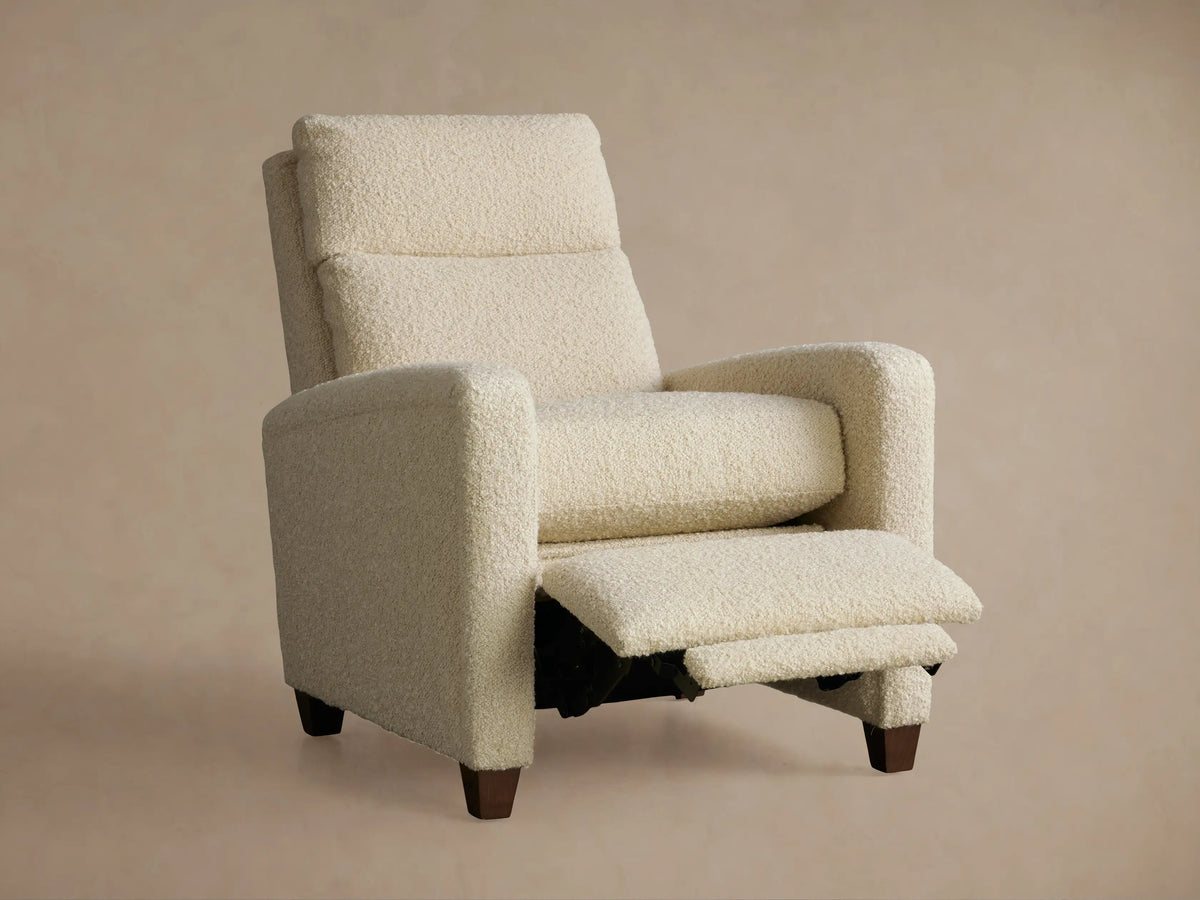 Colfax Motion Recliner in full recline, side view. Cream bouclé fabric, extended footrest, dark wood legs.