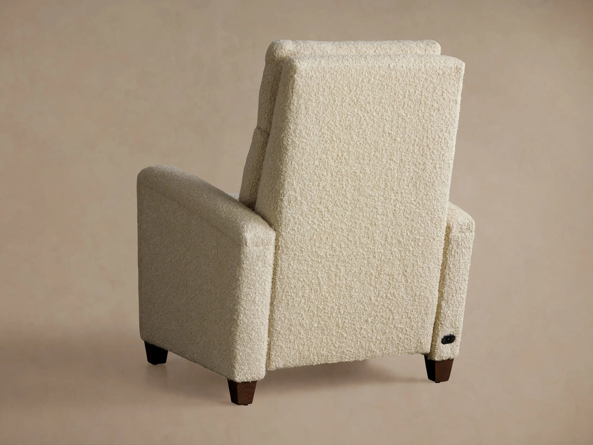 Colfax Motion Recliner, cream boucle fabric, partially reclined with footrest up, angled left on a tan background.