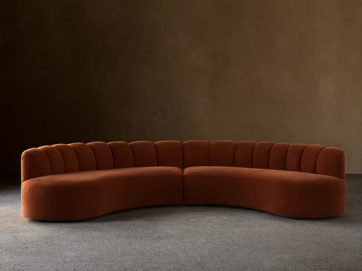 Front view of the Dusty Rose Amira Two-Piece Curved Sectional with channel tufting on the backrest.