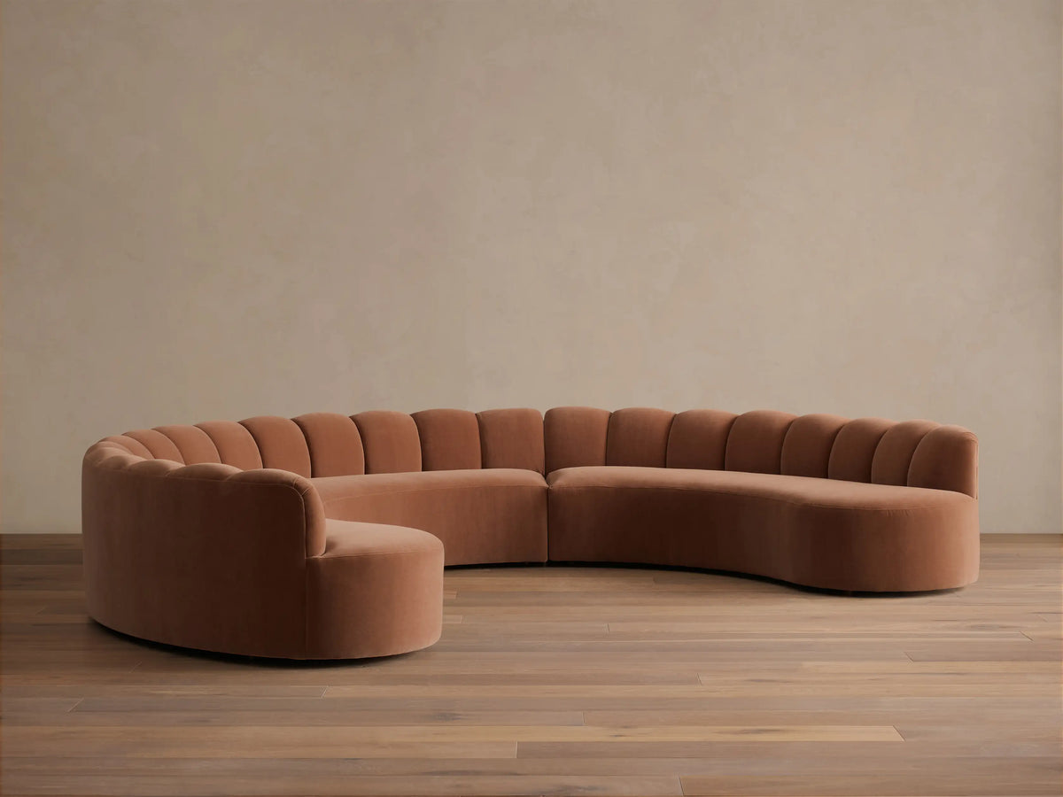 Front view of the Terracotta Amira Three-Piece Curved Sectional with fluted backrests and a low profile.