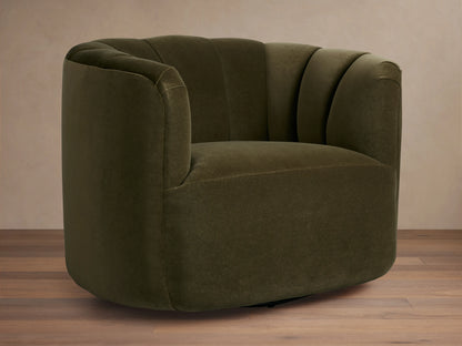 Dark olive green velvet Amira Swivel Chair, rounded form, vertical channel tufting on back, angled view on wood floor.