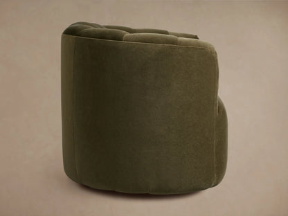 Amira Swivel Chair close-up: dark olive green velvet upholstery with deep, soft pleats on the back and armrest.