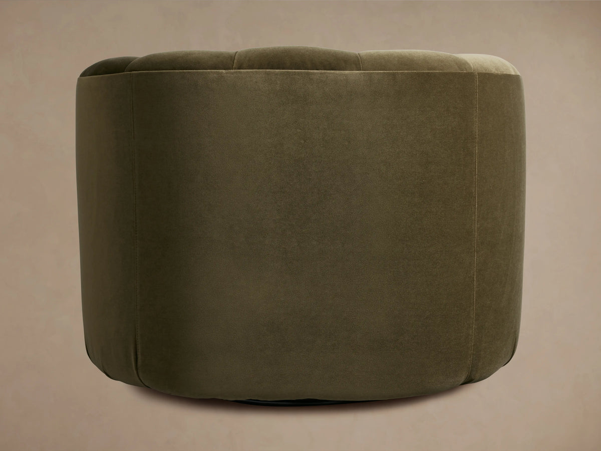Amira Swivel Chair. Rounded, plush olive green chair with a subtly tufted back, seen from a side-rear angle.