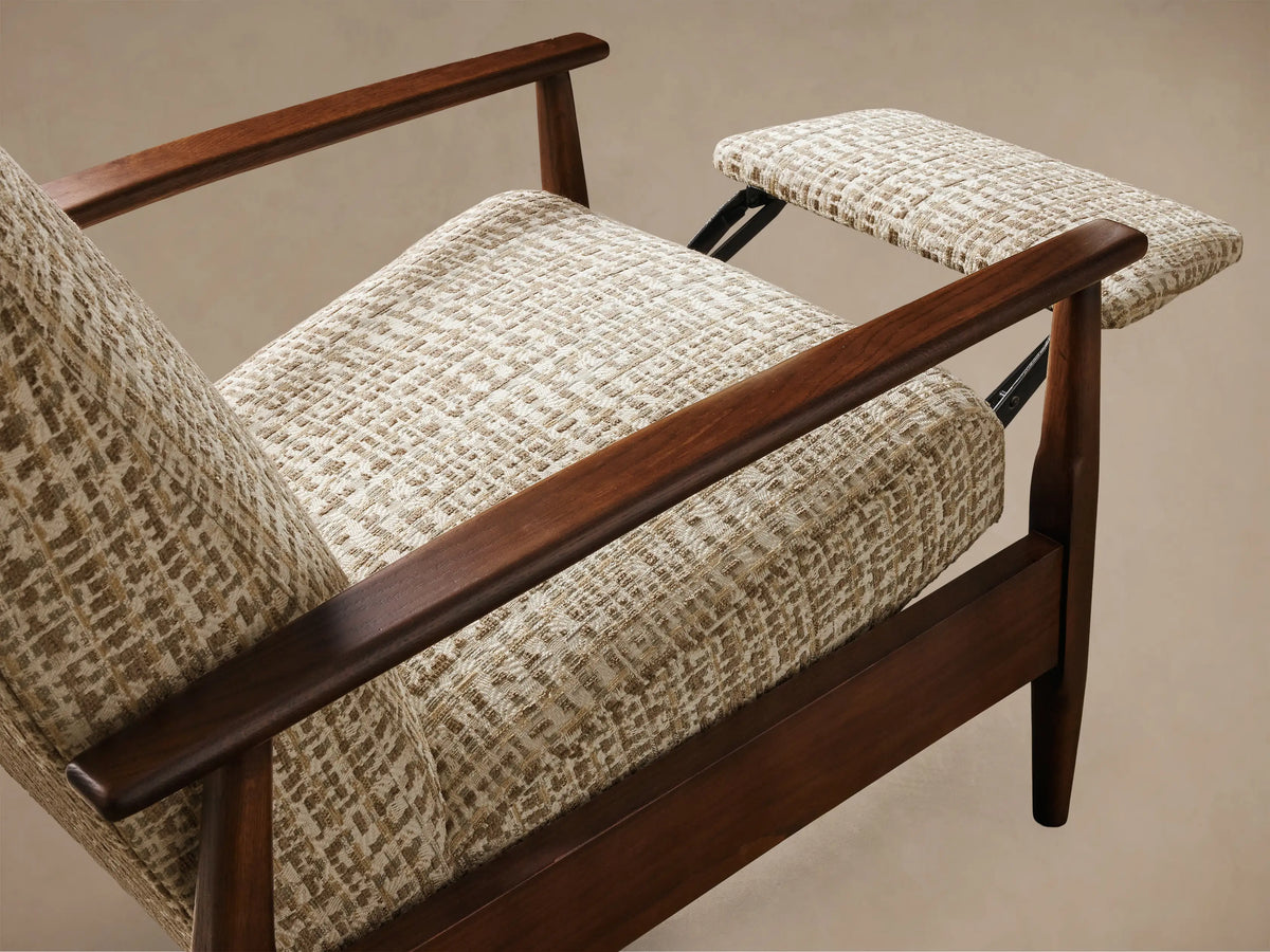 Rear and side view of a high-back lounge chair with a dark brown wooden frame, curved armrests, and beige patterned fabric upholstery.