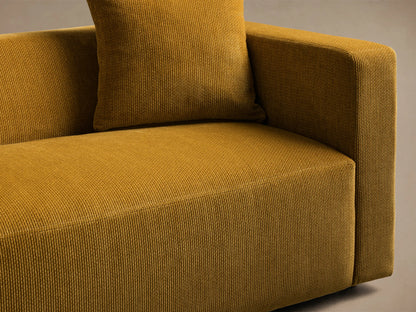 Close-up of the mustard yellow corduroy-like textured fabric on the Brady Sofa, showing the seat, armrest, and cushion.