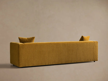 Rear view of the mustard yellow textured fabric Brady Sofa, with two small pillows over the back.