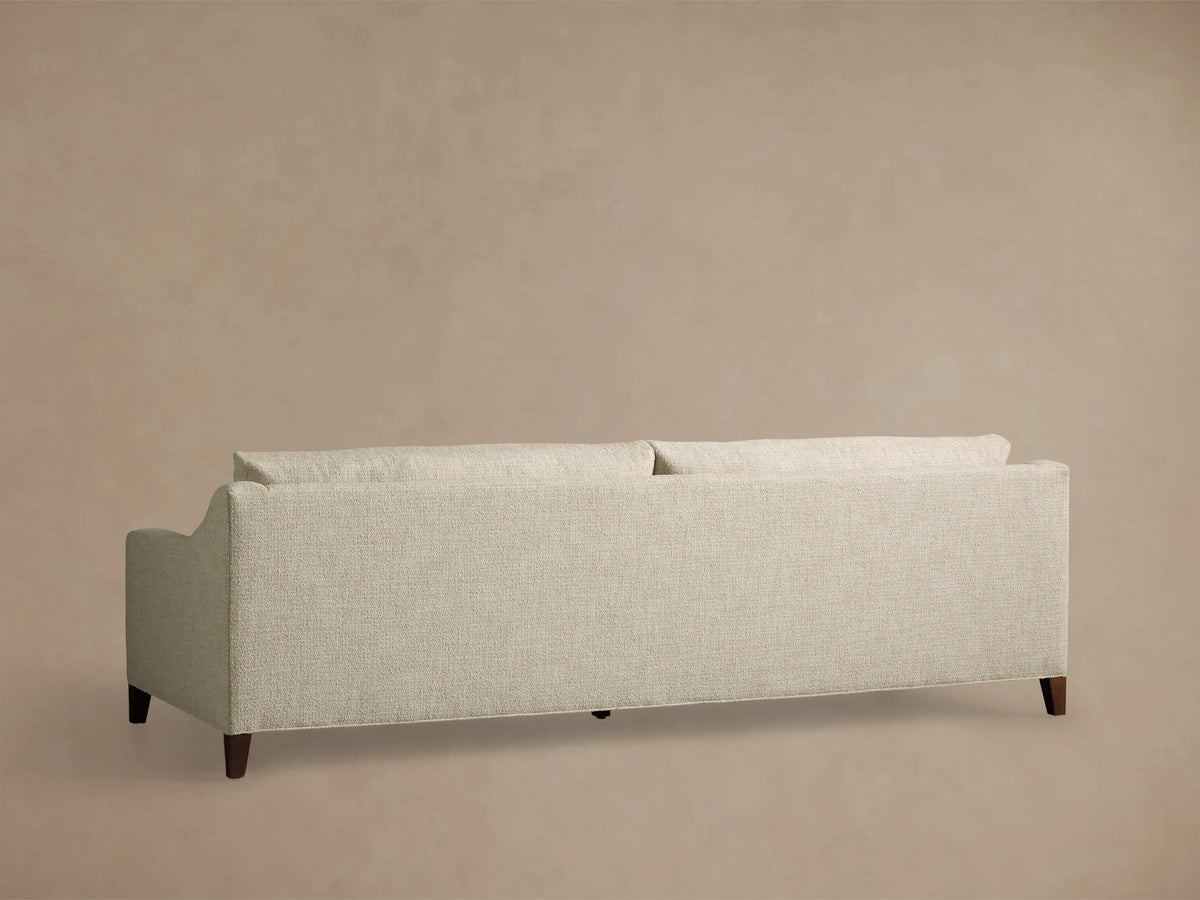 Close-up of the cream textured fabric on the Ashby Elevated Sofa, showing a seat cushion, backrest, and armrest.