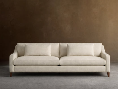 Front view of a cream Ashby Elevated Sofa with woven texture, two seat cushions, two back pillows, and dark mocha finish feet.