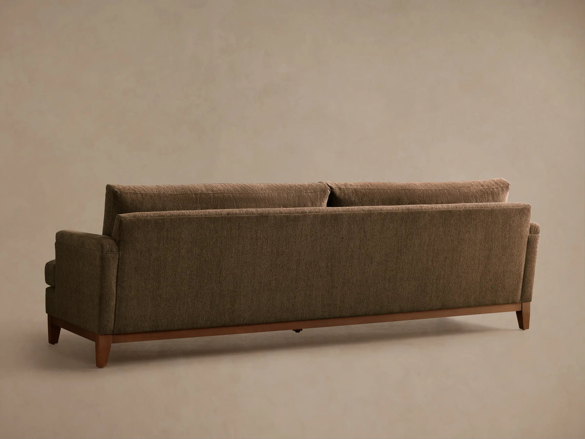 Close-up, angled view of the brown Hunter Sofa, featuring textured fabric on the seat, back, armrest, and a wooden base.