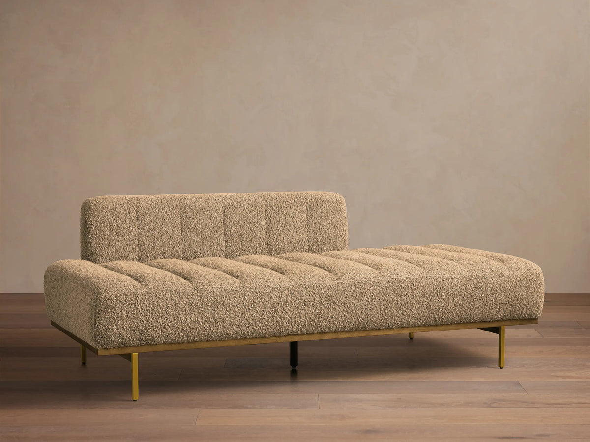 Front view of light brown bouclé Lansing Daybed with vertical channel tufting and gold-toned metal frame.