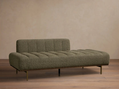 Front view of an olive green boucle chaise lounge with horizontal channel tufting, a dark wood frame, and slender brass legs.