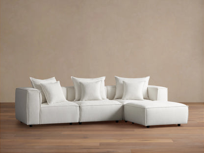 Coburn Four-Piece Sectional in light beige fabric, featuring three seats and a chaise, set against a light brown wall on wood flooring.