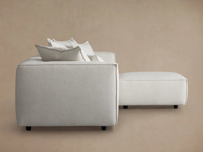 Coburn Four-Piece Sectional in beige, rear view; features three back pillows with clean, modern lines against a neutral background.