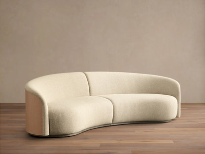 Close-up of the cream bouclé Caden Two-Piece Sectional with a curved light oak veneer side panel and dark plinth.