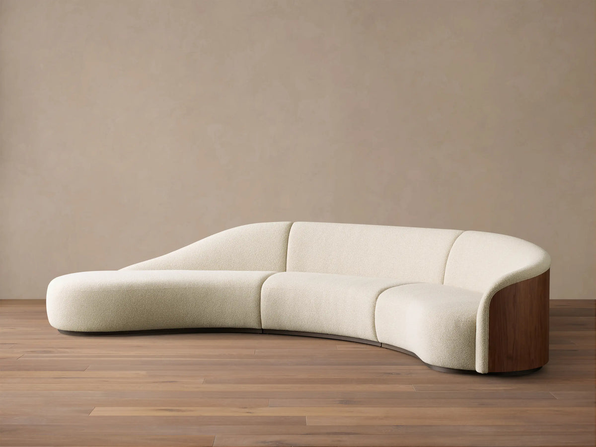 Front view of a Cream Caden Three-Piece Bumper Sectional, curved, with a left bumper and dark walnut veneer end panel.