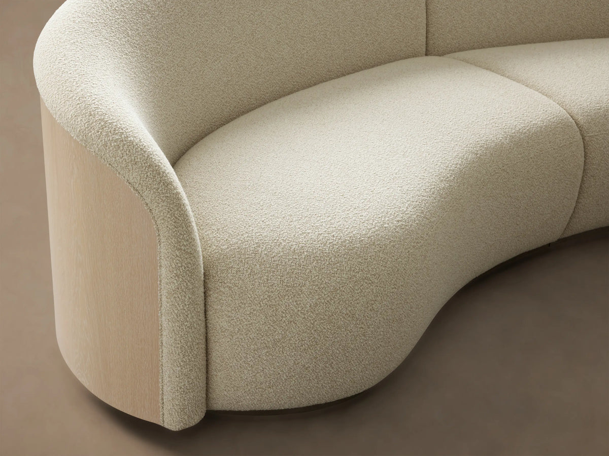 Front view of the cream Caden Three-Piece Bumper Sectional, featuring a left curved arm and right chaise bumper.