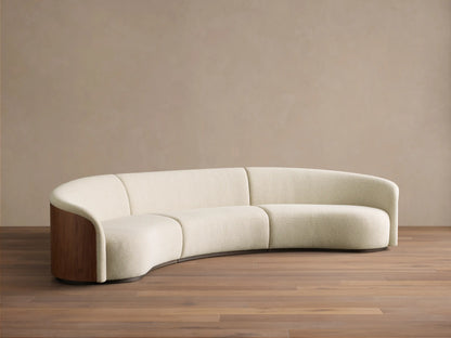 Rear view of the curved Caden Three-Piece Sectional with rich walnut veneer paneling and a cream upholstered top edge.